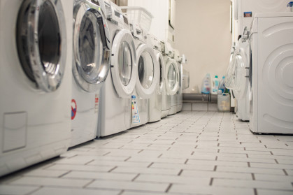 Laundry room of an apartment house in the basement with some washers in a row stock photo