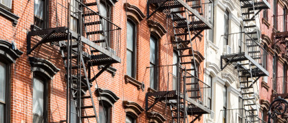 New York City style apartment buildings exterior view with windows and fire escapes