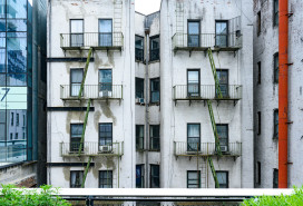 In New York City, United States this older residential building viewed from the High Line has old fashioned fire escapes visible on its exterior.