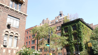 New York City classic building corner architecture. Urban residential house exterior. Real estate property in USA. Typical brick facade, Irving Pl, Manhattan Midtown. Rooftop water tower. Green wall.