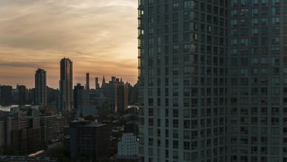 Evening view of Hunters Point waterfront and Manhattan over the East River from a modern condo in Long Island City, Queens.