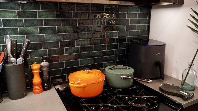 A kitchen backsplash decorated with green tiles.