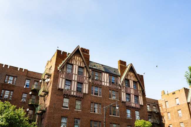 Large apartment building in Bedford Park in the Bronx stands out against a clear blue sky in New York, USA.