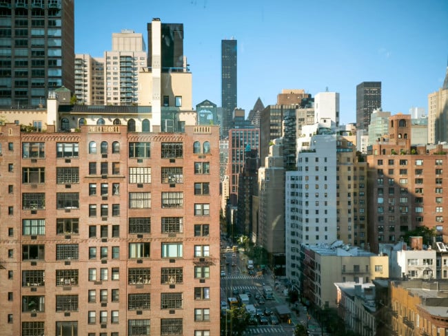 Urban cityscape of New York City showcasing diverse architecture under a clear blue sky.