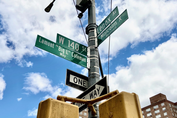 The green street sign at the intersection of West 140th Street and Malcolm X Boulevard, reading those streets and Lamont "Big L" Coleman. 