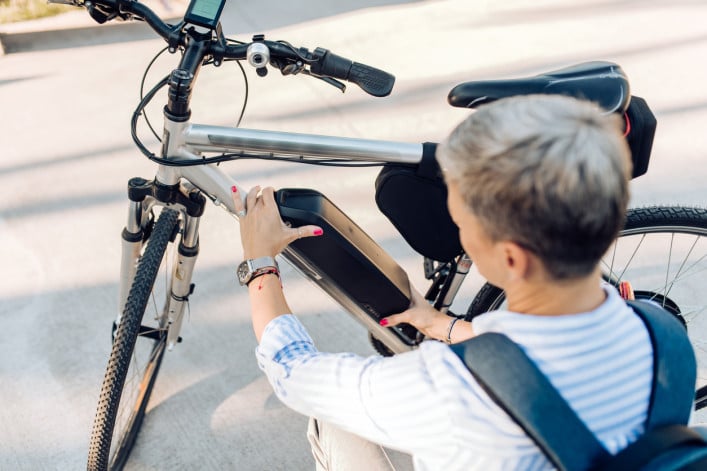 woman changing the battery on her electric bicycle 