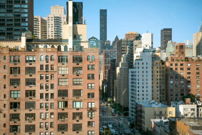 Urban cityscape of New York City showcasing diverse architecture under a clear blue sky.