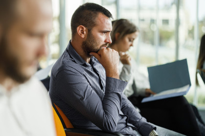 Worried white man, thinking, in board room.