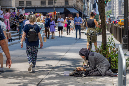Pedestrians and homeless man on 5th Avenue in Manhattan