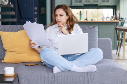 Young freelancer woman get over paperwork while working from living room stock photo