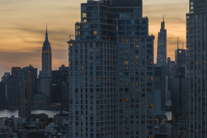 Long Island City waterfront with Empire State Building seen at night.