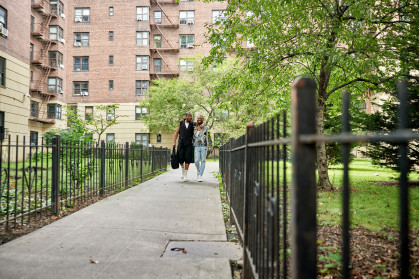 New Yorkers on pedestrian walkway between apartment buildings.