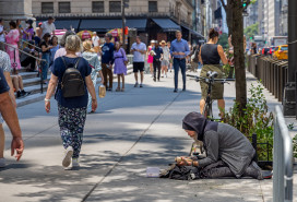 Pedestrians and homeless man on 5th Avenue in Manhattan