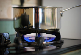 stainless steel saucepan being used on a gas cooktop