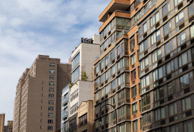 A row of a variety of apartment buildings and skyscrapers along a street in Greenwich Village of New York City