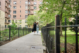 New Yorkers on pedestrian walkway between apartment buildings.