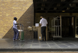 Postman transferring packages to the doorman of a residential building on Madison Avenue