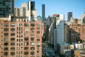 Urban cityscape of New York City showcasing diverse architecture under a clear blue sky.