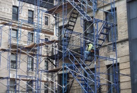 New York, USA - June 21, 2019: Image of a construction worker resting on a scaffold.