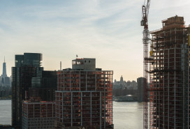 Modern buildings under construction on the waterfront in Greenpoint, Brooklyn with the view of Manhattan with Freedom Tower over the East River. Modern buildings under construction on the waterfront in Greenpoint, Brooklyn with the view of Manhattan with Freedom Tower over the East River.