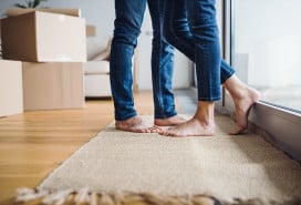 couple standing close, only jeans-clad legs showing