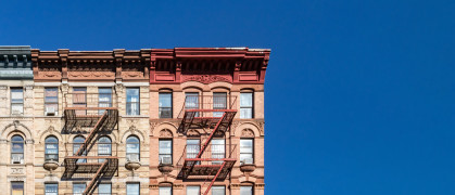 Colorful historic buildings on 4th Street in the East Village of Manhattan in New York City with empty blue sky background