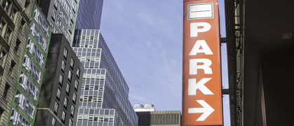 A parking sign in front of a city scape