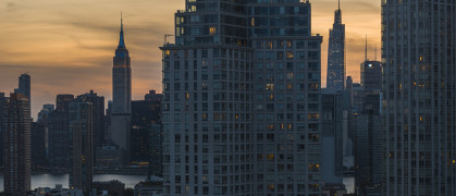 Long Island City waterfront with Empire State Building seen at night.