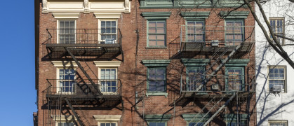 Classic exterior metal fire escapes on or near Greenwich Street in New York City.