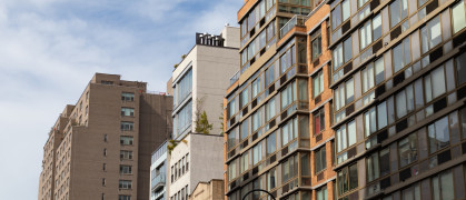 A row of a variety of apartment buildings and skyscrapers along a street in Greenwich Village of New York City