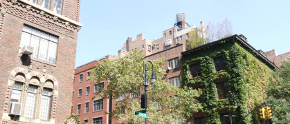 New York City classic building corner architecture. Urban residential house exterior. Real estate property in USA. Typical brick facade, Irving Pl, Manhattan Midtown. Rooftop water tower. Green wall.