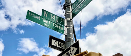 The green street sign at the intersection of West 140th Street and Malcolm X Boulevard, reading those streets and Lamont "Big L" Coleman.