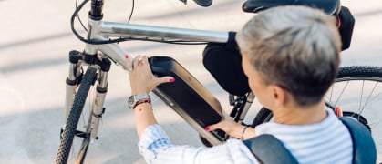 woman changing the battery on her electric bicycle