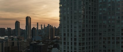 Evening view of Hunters Point waterfront and Manhattan over the East River from a modern condo in Long Island City, Queens.