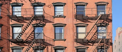 New York City, old apartment building with external fire ladder and ornamental carvings around windows