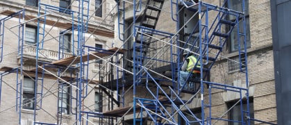 New York, USA - June 21, 2019: Image of a construction worker resting on a scaffold.