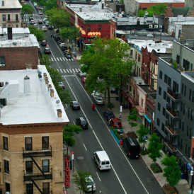 New York City on a hazy day in summer, following traffic on Nostrand Avenue in Crown Heights, Brooklyn.